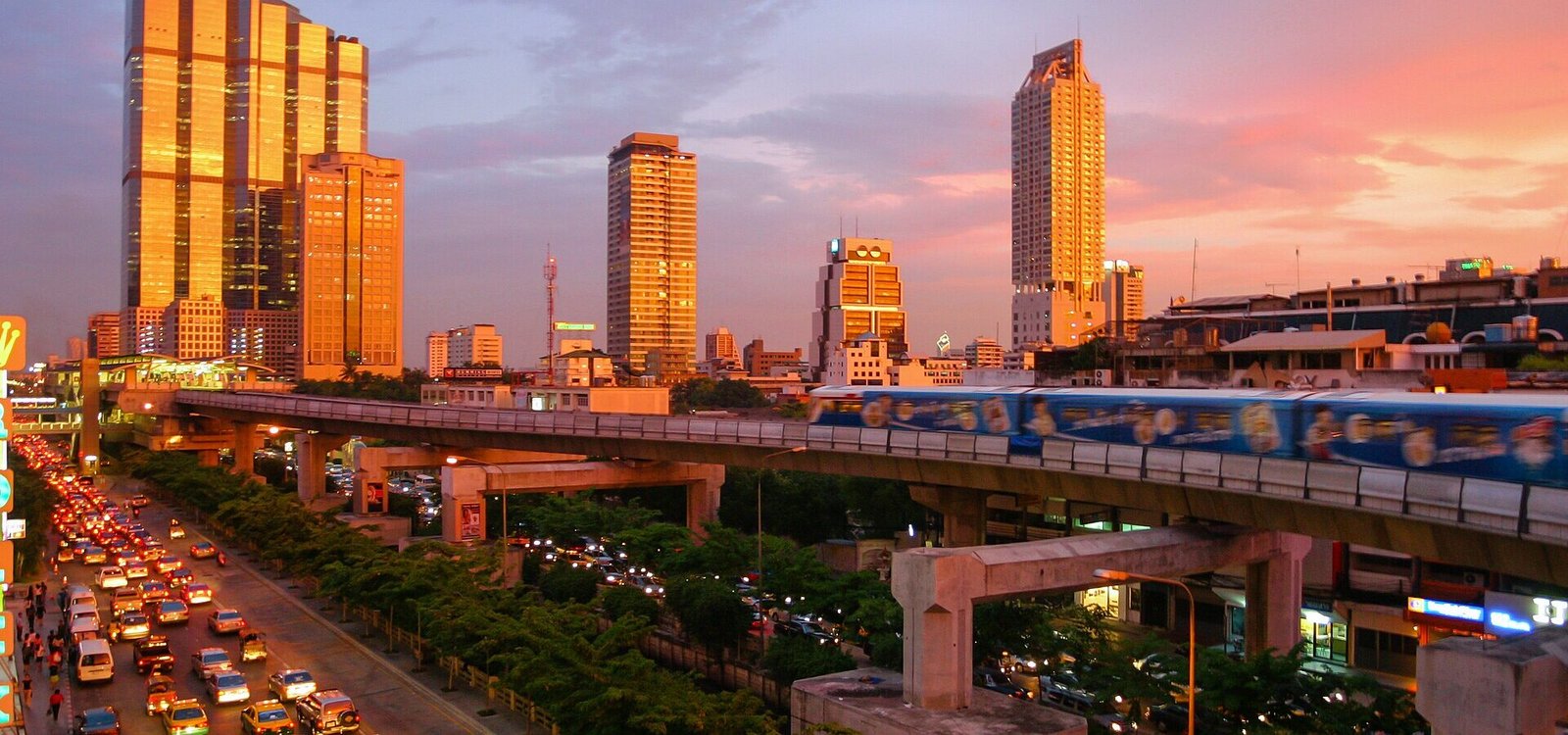 A spectacular sunset in Bangkok, showing the skytrain and modern skyline down Thanon Naradhiwas Rajanagarindra, taken from the corner of Thanon Silom, with the Empire Tower and the