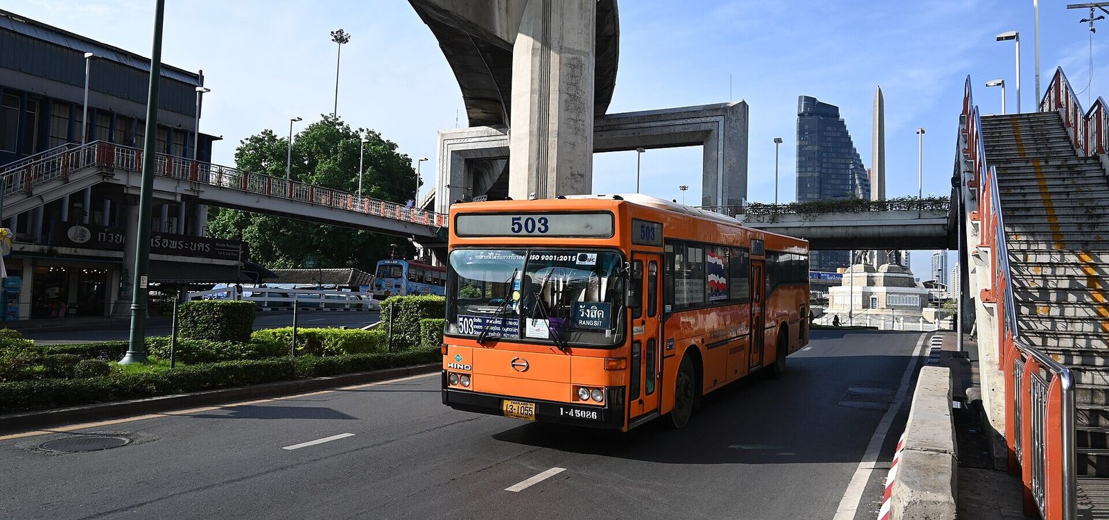 BMTA's Hino RU1J route 503 side number 1-45086 distinctive for its Thai national flag sticker on the side of the bus, Exiting the Victory Monument towards Rang sit in Bangkok, Thai